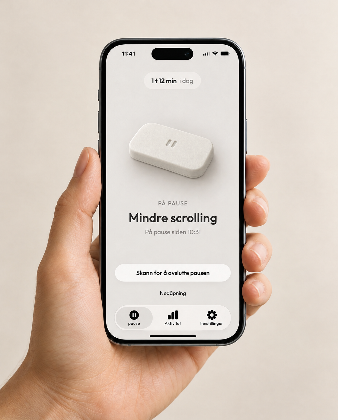 En hånd holder en iPhone med pause-appen i aktiv pause og den nye, rene brikka på skjermen.